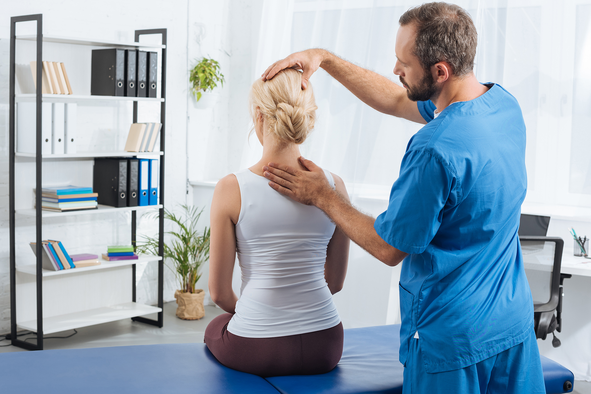 Professional Chiropractor assessing patient's neck and shoulders